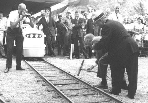 A golden spike is driven into the ground on August 29, 1963.