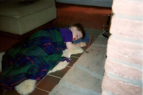 Tim fast asleep in front of the fire at our camp