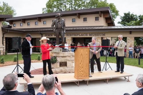 Cutting the ribbon during the grand opening ceremony for the John Wayne Birthplace Museum in Winterset. Left to right: Barry Corbin (actor & Birthplace board member), Aissa Wayne (John Wayne’s daughter), Joe Zuckschwerdt (Birthplace & Museum President), and Christopher Mitchum (actor). 5/23/2015 Photo by John Pemble